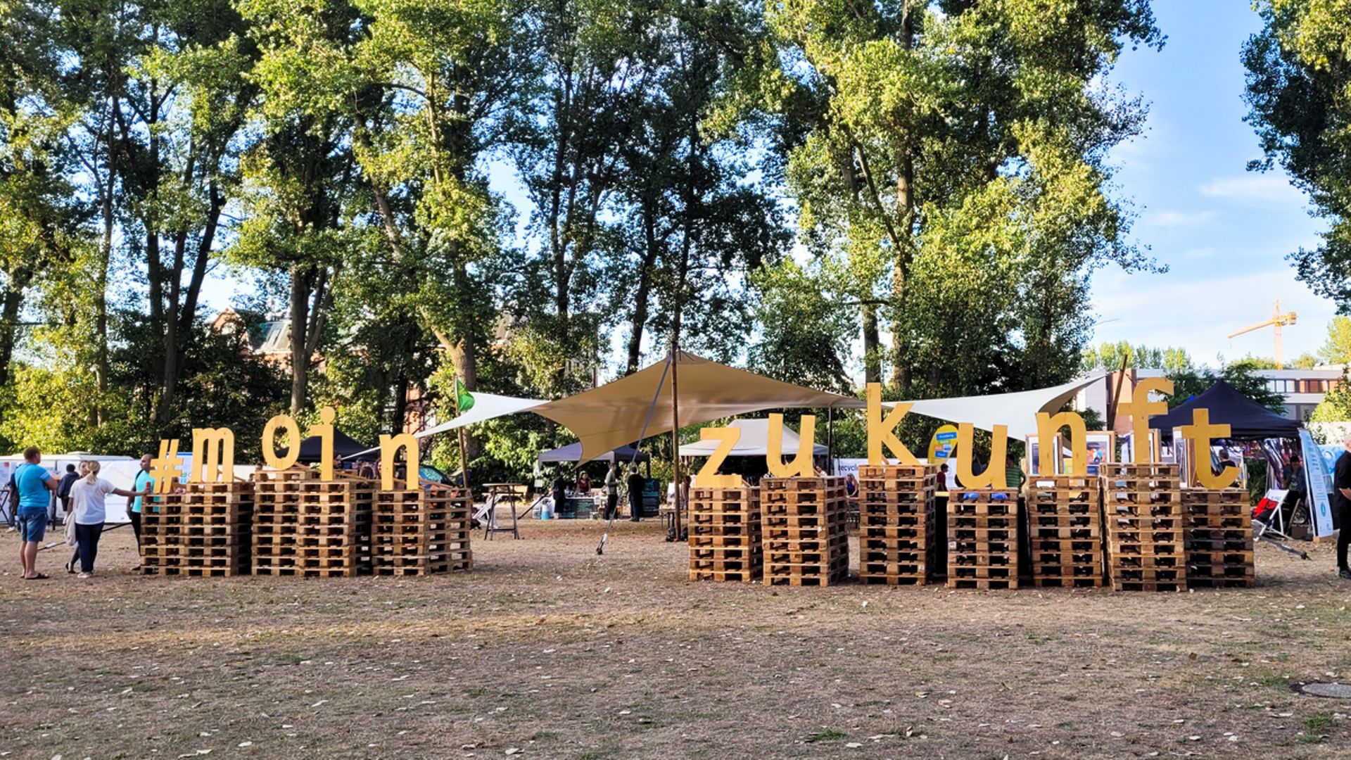 Große Holzbuchstaben "#moinzukunft" auf Paletten platziert