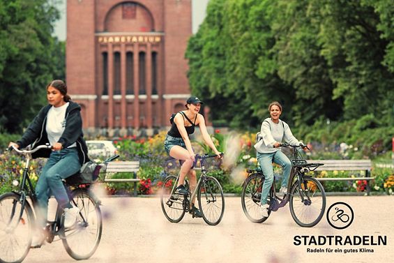 Radfahrende Menschen vor dem Planetarium im Stadtpark