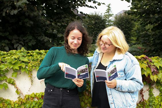 Zwei Frauen lesen im klimafreundlichen Hamburg-Guide.